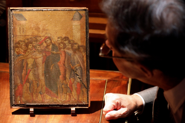 미술 전문가 에릭 투르긴이 르네상스 피렌체학파의 시조로 불리는 화가 조반니 치마부에의 작품 ‘조롱받는 예수’를 살펴보고 있다./로이터연합뉴스