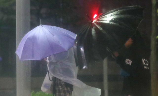 제17호 태풍 ‘타파’가 다가온 22일 오후 울산 남구 한 거리에서 시민이 우산으로 비와 바람을 막으며 걸어가고 있다. /연합뉴스