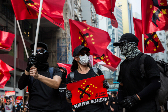 29일(현지시간) 홍콩 시위대가 중국 오성홍기에 독일의 나치 문양을 합성한 ‘차이나치’ 깃발을 들고 도심을 행진하고 있다.  /홍콩=AFP연합뉴스