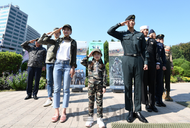 30일 서울광장에서 열린 '제71주년 국군의 날 기념, 국군 응원 캠페인'에서 밀리터리룩 복장을 한 모델과 국군장병들이 함께 경례하고 있다./성형주기자 2019.09.30