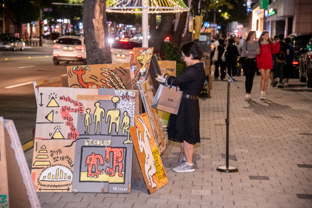 서울 강남구 논현 가구거리에서 한 시민이 ‘아트프라이즈 강남’ 전시 작품을 살펴보고 있다. /사진제공=암웨이