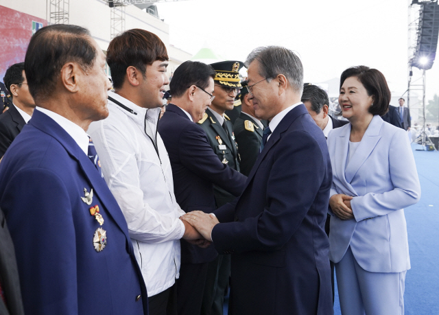 문재인 대통령이 1일 대구 공군기지에서 제71주년 국군의날 기념식 후 북한군 목함지뢰 도발로 두 다리를 잃은 하재헌(앞줄 왼쪽 두번째) 예비역 중사를 격려하고 있다.   /연합뉴스