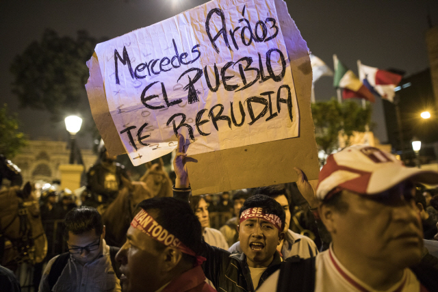 A supporter of Peruvian President Martin Vizcarra holds the Spanish message: “Meche the people hate you,” referring to Vice President Mercedes Araoz, outside Congress after Vizcarra dissolved the legislature in Lima, Peru, Monday, Sept. 30, 2019. Opposition legislators defied Vizcarra‘s order dissolving congress by voting to suspend him from office and swearing in Vice President Mercedes Araoz as the South American nation’s new leader. (AP Photo/Rodrigo Abd)        <저작권자(c) 연합뉴스, 무단 전재-재배포 금지>