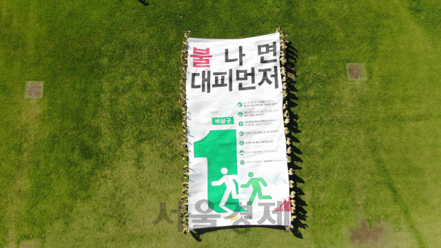 지난달 24일 천안 중앙소방학교 운동장에서 제96기 교육생들이 ‘불나면 대피먼저’ 캠페인 현수막을 펼쳐보이고 있다. /사진제공=소방청