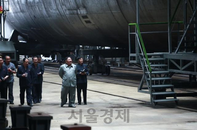 김정은 북한 국무위원장이 새로 건조한 잠수함을 시찰했다고 조선중앙TV가 지난 7월 23일 보도했다. 김 위원장이 수행간부들과 잠수함을 올려다보며 웃고 있다./연합뉴스