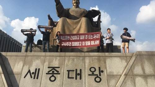 4일 오후 광화문광장 세종대왕상에 올라가 시위를 벌이고 있는 진보 대학생단체 학생들 /한국대학생진보연합 페이스북