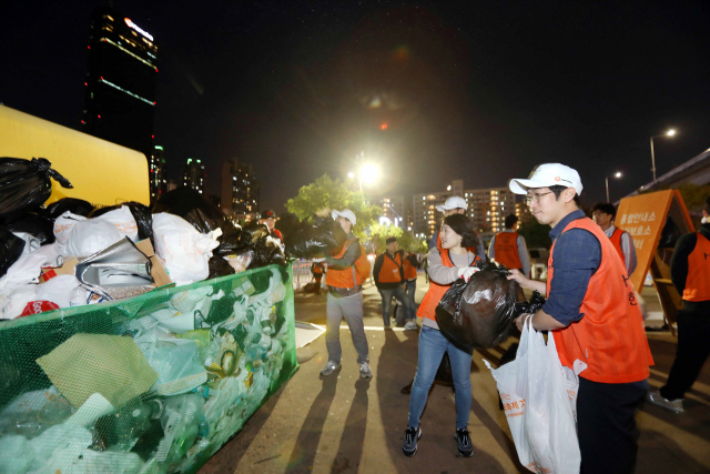 한화그룹 임직원이 지난 5일 서울 여의도 63빌딩 앞과 이촌지구 한강공원 일대에서 진행된 ‘한화와 함께하는 서울세계불꽃축제 2019’ 종료 후 클린 캠페인을 펼치고 있다. /사진제공=한화