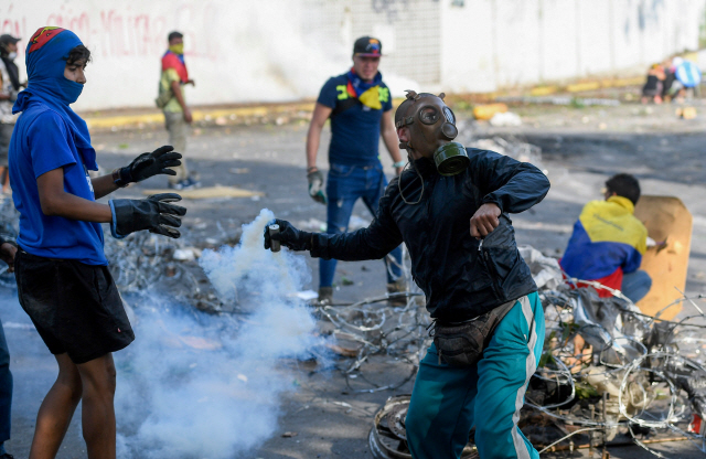 지난 5월 베네수엘라 카라카스에서 반정부 시위대가 니콜라스 마두로 대통령의 퇴진을 요구하며 수류탄을 던지는 등 격한 무력 시위에 나서고 있다. /카라카스=AFP연합뉴스