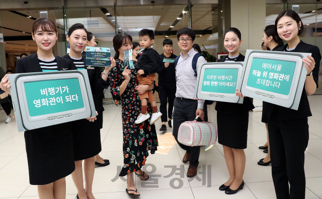 에어서울이 국내 저비용 항공사(LCC) 최초로 기내 모니터를 통한 영화 상영 서비스 '하늘 위 영화관' 서비스를 시작을 앞두고 있는 7일 서울 강서구 김포공항 국내선 청사 입국장 앞에서 에어서울 승무원들이 관광객들에게 에어서울 내 다양한 음료와 스낵 등을 판매하고 있는 'CAFE MINT' 이용권을 나눠주며 홍보하고 있다. 10일부터 에어서울의 중국(장자제·린이), 동남아시아, 괌 등 중거리 노선 탑승객들은 좌석마다 설치된 기내 개별 모니터를 통해 영화를 시청할 수 있으며 단거리 노선에 해당하는 일본 노선에서는 영화 상영 서비스를 하지 않지만, 대신 코믹 영상 등을 시청할 수 있다./이호재기자.