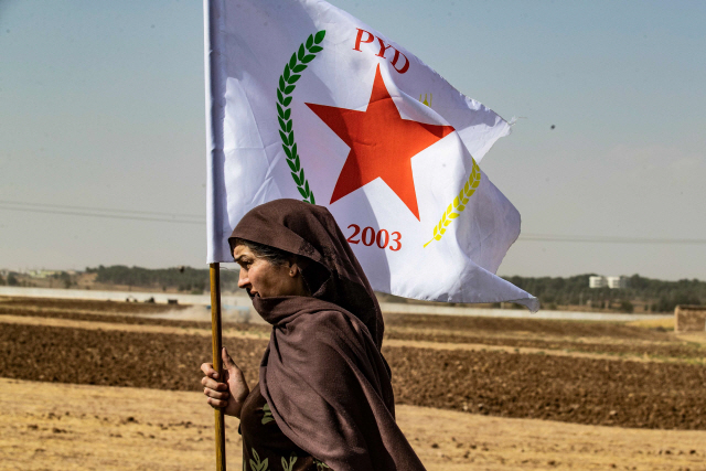 시리아 쿠르드족 여성이 6일(현지시간) 하사카주의 라스 알아인에서 민주연합당(PYD) 깃발을 흔들고 있다. /라스 알아인=AFP연합뉴스