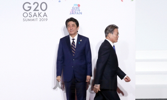 문재인 대통령이 지난 6월 28일 오사카에서 열린 G20 정상회의 공식환영식에서 아베 신조 일본 총리와 악수한 뒤 이동하고 있다./연합뉴스