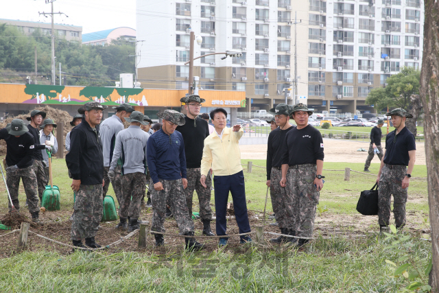 이병환 성주군수(가운데 노란상의)가 군 장병들가 태풍 피해지역을 방문해 복구방법을 논의하고 있다.