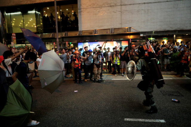 3일(현지시간) 홍콩의 타이쿠 역 주변에서 ‘범죄인 인도 법안’(송환법) 반대 시위자들이 방패를 든 경찰에 맞서 우산을 세워 들고 있다./연합뉴스