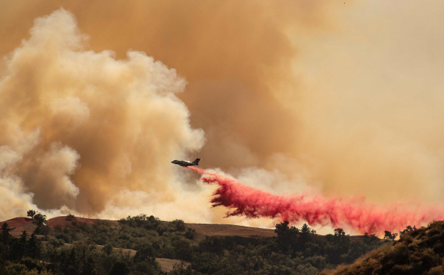 산불이 발생한 캘리포니아 뉴홀 지역에서 소방헬기가 새들리지 파이어의 화재진압 활동을 하고 있다. /뉴홀=AFP연합뉴스