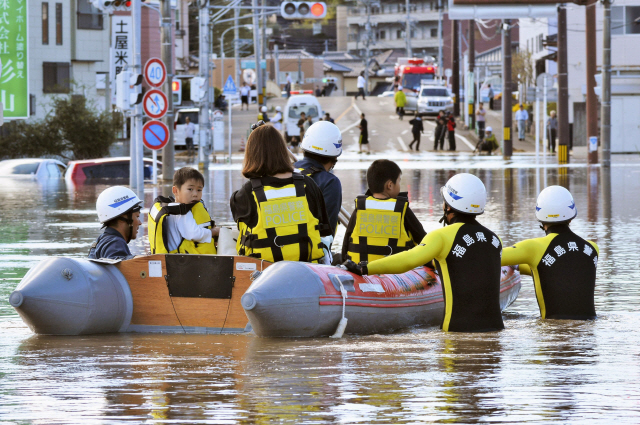 13일 일본 동북부 후쿠시마현 이와키시에서 제19호 태풍 하기비스로 침수피해를 당한 주민들이 구명보트로 구조되고 있다.  /이와키=AP연합뉴스