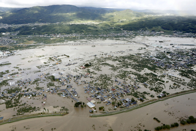 태풍 ‘하기비스’가 몰고 온 폭우 속에 13일 일본 나가노현 나가노시에서 지쿠마강의 무너진 둑 주위 주거지가 온통 물에 잠겼다./나가노=로이터연합뉴스