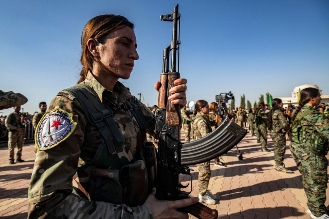 13일(현지시간) 시리아 쿠르드족 마을인 데릭에서 전날 친터키 시리아 반군들에 의해 처형된 쿠르드족 여성 지도자 헤브린 칼라프의 장례식이 거행되고 있다. 터키군이 시리아 북동부 지역에서 군사작전을 닷새째 이어가고 있는 가운데 미국으로부터 버림받은 쿠르드족 자치정부는 이날 과거 적이었던 시리아 정부와 협력하기로 합의했다.  /데릭=AFP연합뉴스