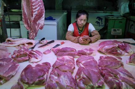 중국 베이징의 한 돼지고기 가게에서 상인이 손님을 기다리고 있다. /EPA연합뉴스