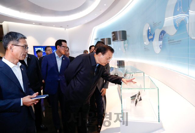 리커창 (오른쪽) 중국 총리가 지난 14일 삼성전자 시안 공장을 방문해 반도체 제품들을 살펴보고 있다./연합뉴스