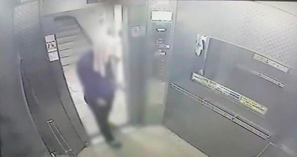 순천의 한 아파트에서 피의자 A씨가 수건으로 얼굴을 가린 채 엘리베이터에 타는 모습. /연합뉴스