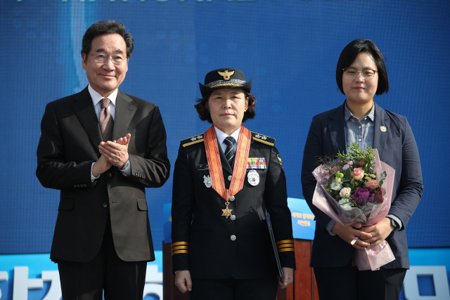 이낙연(왼쪽) 국무총리가 21일 인천 송도컨벤시아에서 열린 ‘경찰의 날 기념식’에서 이은정(가운데) 중앙경찰학교장에게 홍조근정훈장을 수여한 뒤 기념촬영하고 있다. /연합뉴스