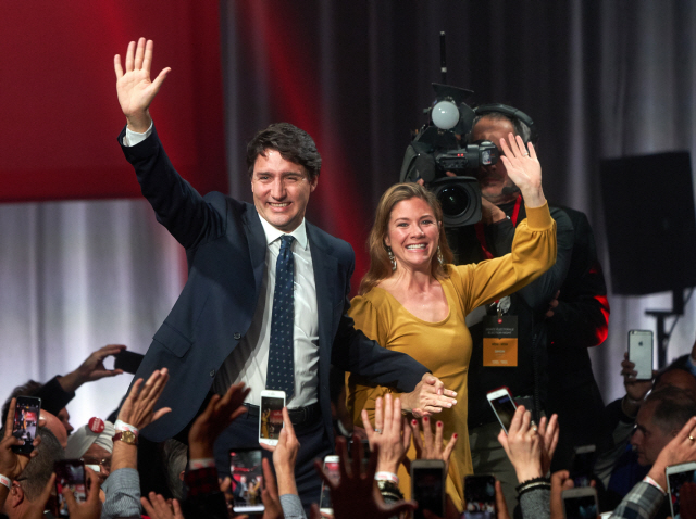 쥐스탱 트뤼도(왼쪽) 캐나다 총리 부부가 21일(현지시간) 퀘백주 몬트리올에서 지지자들에게 손을 흔들며 총선 승리를 자축하고 있다. /몬트리올=EPA연합뉴스