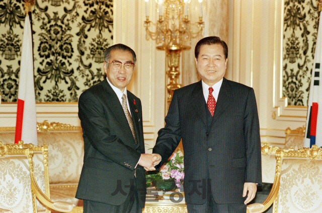 김대중 대통령과 오부치 게이조 일본총리가 1998년 10월 8일 도쿄에서 한일정상회담에 앞서 악수를 하고 있다.