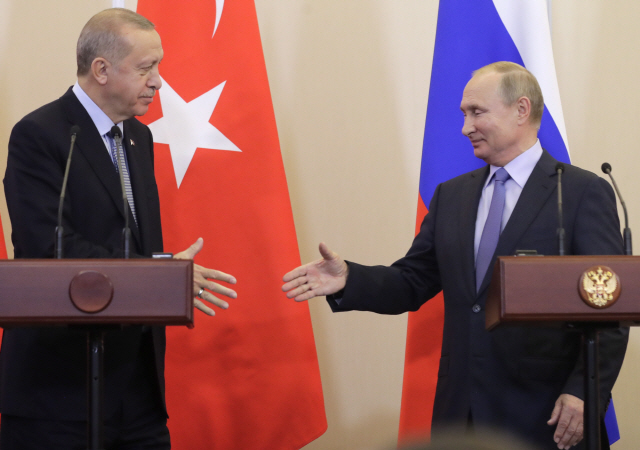 블라디미르 푸틴(오른쪽) 러시아 대통령과 레제프 타이이프 에르도안 터키 대통령이 22일(현지시간) 러시아 남부 휴양도시 소치에서 정상회담 후 공동 기자회견을 마치고 악수를 나누고 있다. /소치=타스연합뉴스