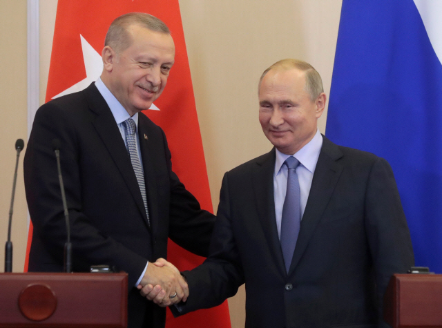 블라디미르 푸틴(오른쪽) 러시아 대통령과 레제프 타이이프 에르도안 터키 대통령이 22일(현지시간) 러시아 소치에서 정상회담 후 악수하고 있다. /소치=로이터연합뉴스