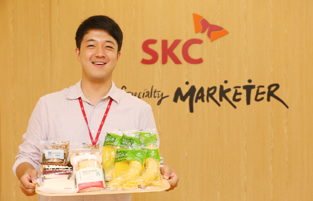 SKC 직원이 자사 친환경 생분해 필름을 포장재로 사용한 스타벅스 제품을 소개하고 있다. /사진제공=SKC