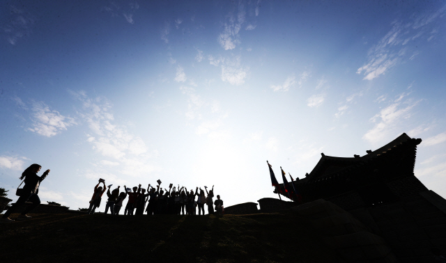 22일 오전 경기도 수원시 창룡문을 찾은 초등학생들이 파란 가을 하늘을 배경으로 사진을 찍고 있다. /연합뉴스