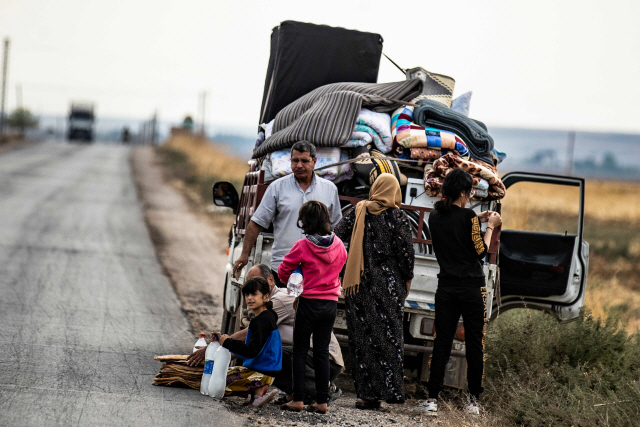 쿠르드족 가족이 지난 22일(현지시간) 터키 접경의 시리아 다르바시야에서 피난을 하던 중 도로에 잠시 머물러 있다. /다르바시야=AFP연합뉴스