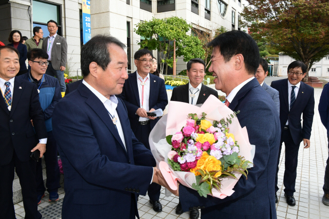 김충섭(앞줄 왼쪽) 김천시장이 지난 24일 시청을 찾은 배기철 대구 동구청장에게 꽃다발을 건네며 환영하고 있다./사진제공=김천시