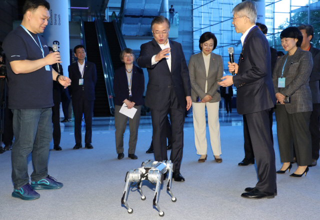 문재인 대통령이 28일 오전 강남구 코엑스에서 열린 인공지능 콘퍼런스 ‘데뷰(DEVIEW) 2019’에서 로봇 미니치타를 보고 있다. 이 로봇은 이번 행사에서 국내 최초로 공개됐다. /연합뉴스