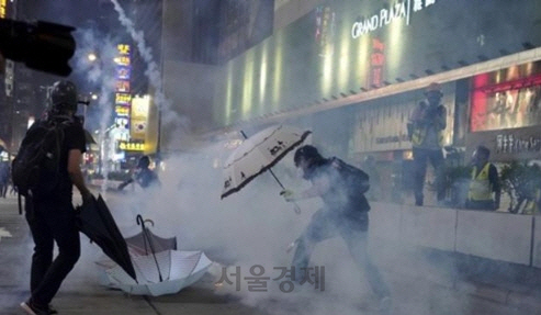 27일 경찰이 발사한 최루탄을 우산으로 막는 홍콩 시위대/AP=연합뉴스