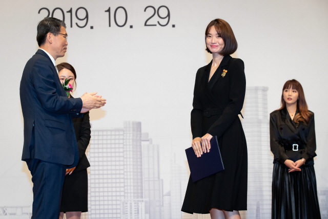 은성수(왼쪽) 금융위원장이 29일 서울 여의도 63빌딩에서 열린 제4회 금융의날 행사에서 대통령표창을 받은 영화배우 신민아 씨에게 상장을 준 후 박수를 치고 있다. /사진제공=금융위원회