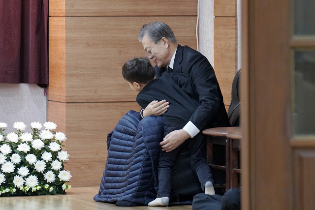 문재인 대통령이 30일 오전 부산 남천성당에 마련된 어머니 빈소에서 손자를 안아주고 있다./사진제공=청와대