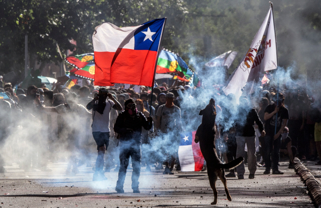 지하철 요금 인상으로 촉발된 칠레 시위가 열흘 넘게 이어지고 있는 가운데 28일(현지시간) 수도 산티아고에서 반정부 시위대와 경찰이 충돌하고 있다. /산티아고=AFP연합뉴스