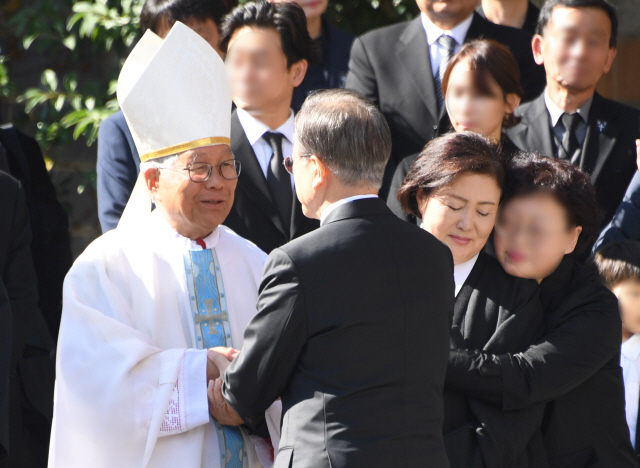 문재인 대통령이 31일 부산 남천성당에서 모친 고 강한옥 여사의 발인을 엄수하며 천주교대전교구장 유흥식 라자로 주교와 대화를 나누고 있다./연합뉴스