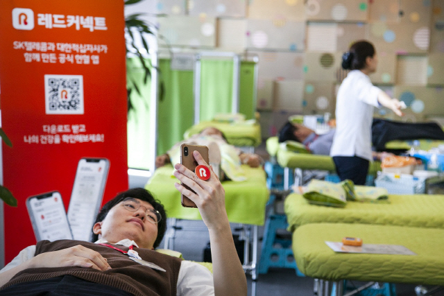 SK텔레콤 직원이 ‘레드커넥트’ 애플리케이션을 통해 헌혈한 혈액의 건강정보와 이동경로를 확인하고 있다./사진제공=SK텔레콤