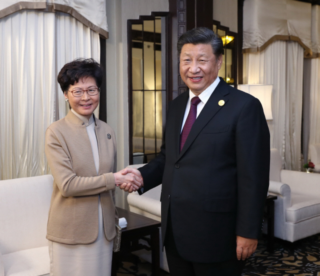 4일(현지시간) 상하이 국제수입박람회에서 시진핑(오른쪽) 중국 국가주석이 캐리 람 홍콩 행정장관을 만나 악수하고 있다./상하이=신화연합뉴스