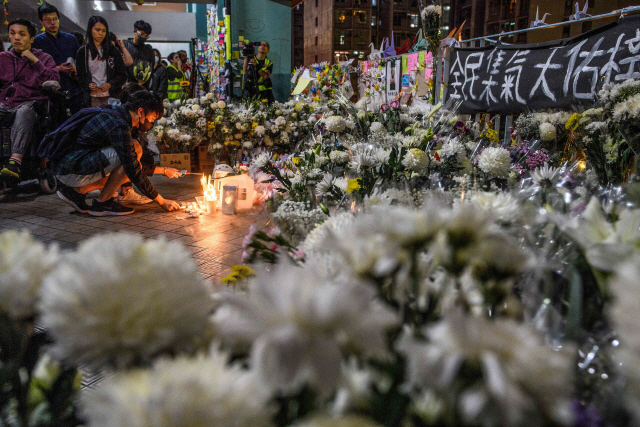 지난 8일 홍콩에서 시민들이 촛불을 밝히며 시위현장 근처에서 추락사한 대학생 차우츠록을 추모하고 있다. 차우는 지난 4일 시위현장 부근의 주차장에서 추락해 머리를 심하게 다친 후 이날 사망했다./AFP연합뉴스