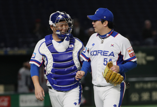 한국 야구 대표팀의 선발투수 양현종(오른쪽)과 포수 양의지가 11일 프리미어12 슈퍼라운드 미국전에서 5회를 무실점으로 마친 뒤 밝은 표정으로 더그아웃으로 향하고 있다. /연합뉴스