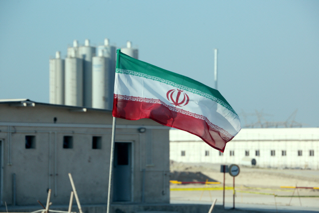 지난 10일(현지시간) 이란 부시르의 원자력발전소 앞에 이란 국기가 걸려 있는 모습. /부시르=AFP연합뉴스