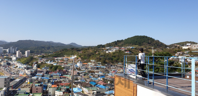 논골담길의 한 게스트하우스에서 관광객이 한때 번창했던 묵호동을 내려다보고 있다.