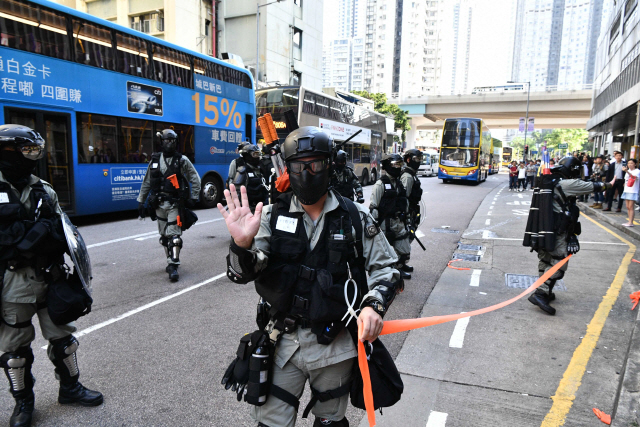 11일(현지시간) 시위 도중 한 참가자가 경찰이 쏜 실탄에 맞아 쓰러진 홍콩 사이완호 거리에서 경찰관들이 통행 차단선을 설치하고 있다. /홍콩=AFP연합뉴스