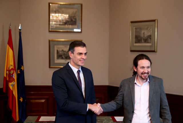 12일(현지시간) 스페인 수도 마드리드 소재 국회에서 페드로 산체스(왼쪽) 임시총리와 파블로 이글레시아스 포데모스 대표가 악수하고 있다./마드리드=로이터연합뉴스