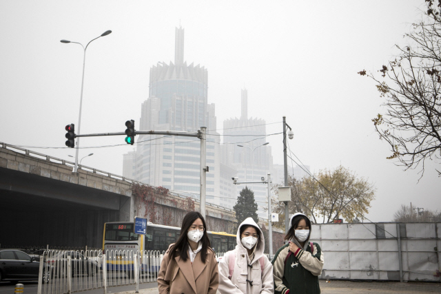 최악의 스모그가 덮친 지난해 11월14일 베이징 시민들이 마스크를 쓴채 거리를 지나가고 있다. /블룸버그