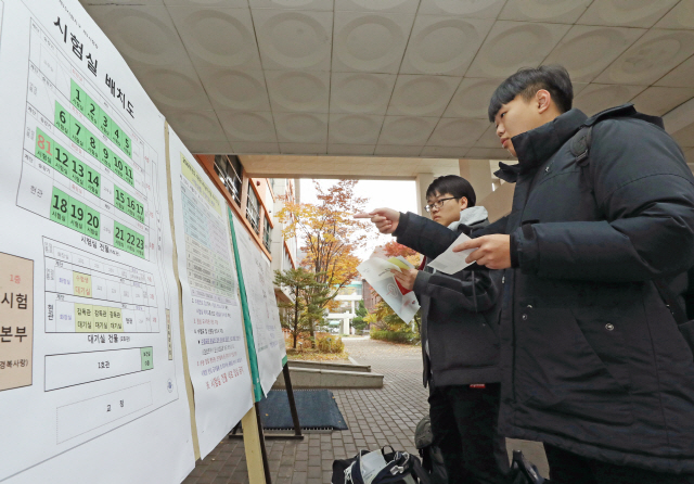 수능을 하루 앞둔 13일 서울 종로구 경복고등학교에서 수험생들이 수험 배치도 및 주의사항을 살펴보고 있다. /연합뉴스