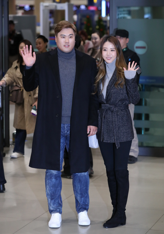 류현진(왼쪽)이 14일 아내 배지현씨와 함께 귀국해 팬들을 향해 손을 들어 보이고 있다. /연합뉴스